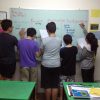 Students solving equations on the white board