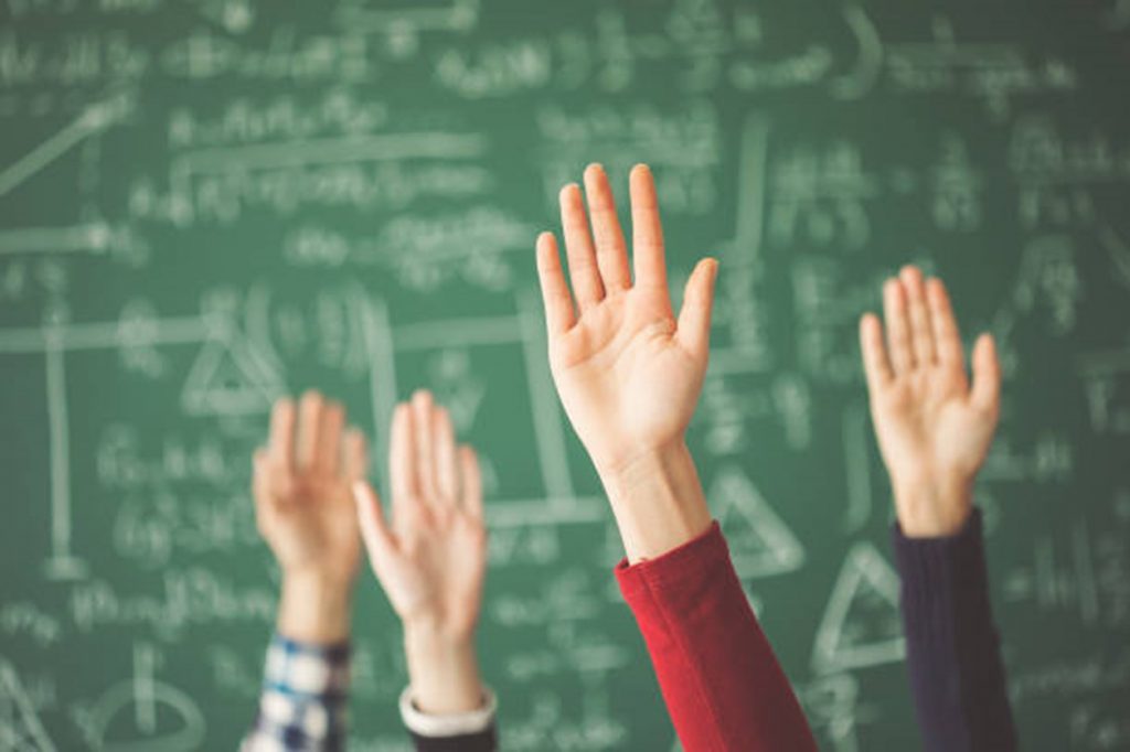 Students raising their hand in class