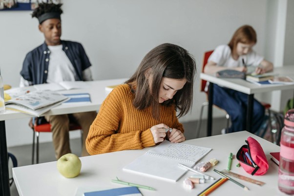 A young girl studying and taking down notes