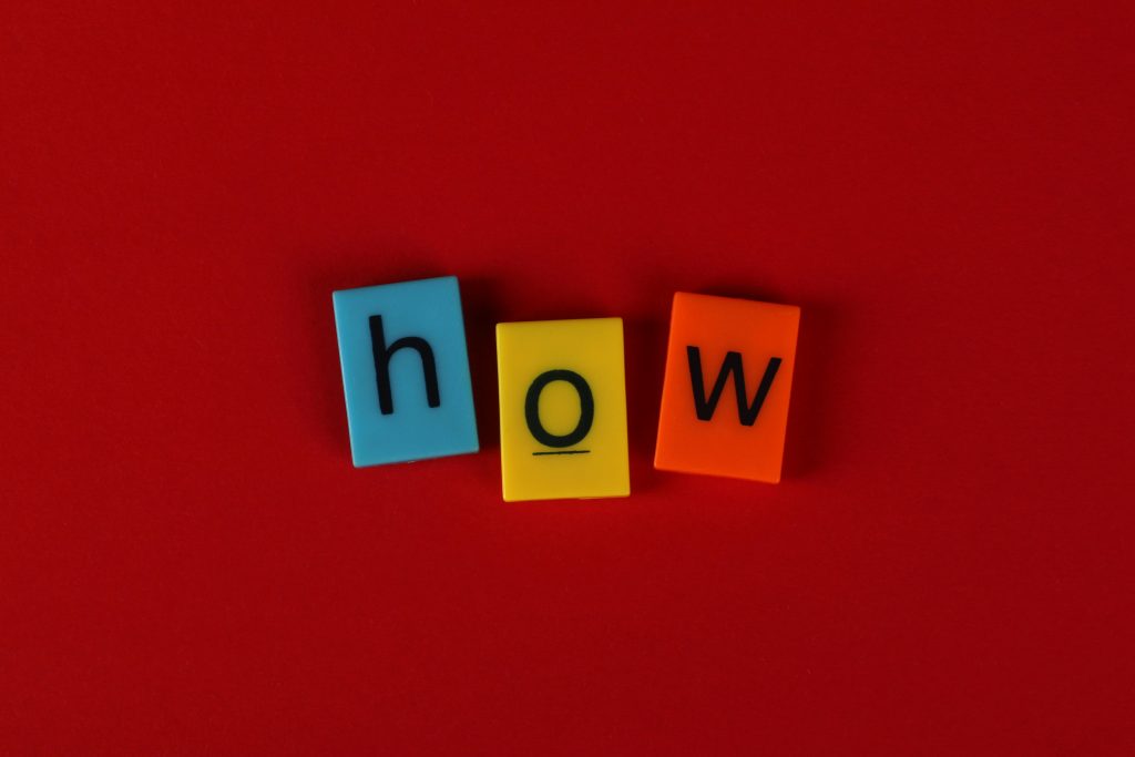 The word "how" spelled out with blue, yellow, and orange letter tiles