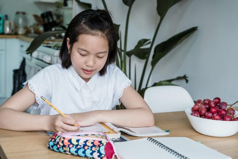 A student is studying and writing on her notebook