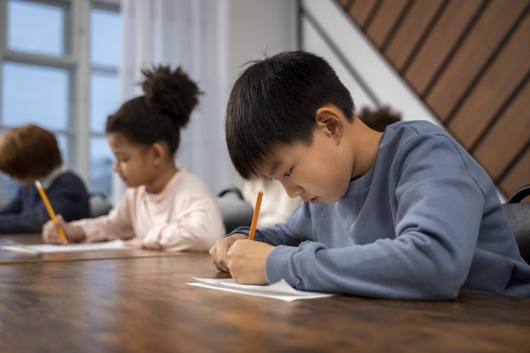 A young student taking a written exam in school