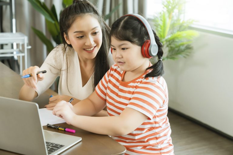 Mother teaching daughter online learning