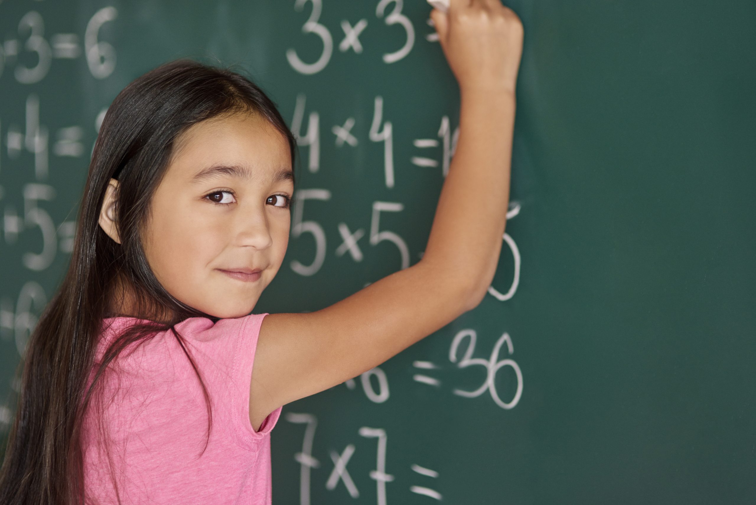 Girl making some exercises on the blackboard