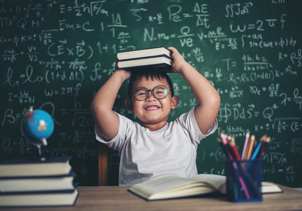 Boy with books sitting in the classroom