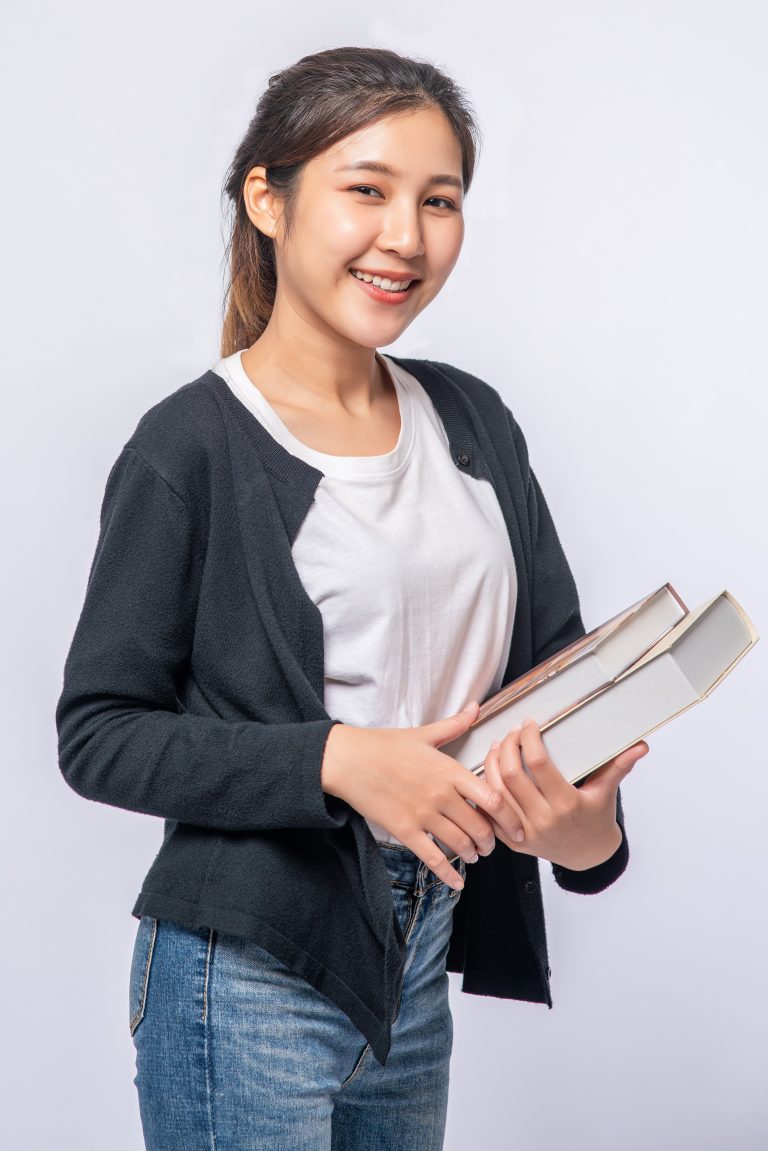 Smiling young woman holding books
