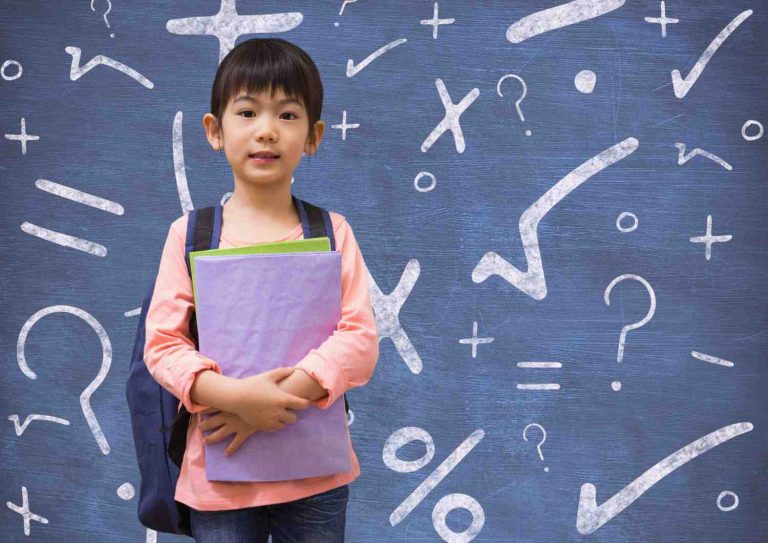 Young child holding a notepad with Math symbols