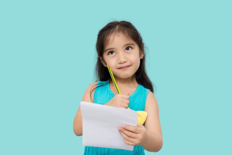 Young girl thinking while holding a piece of paper and pencil