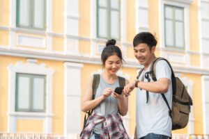 Two students with backpacks studying together on a phone