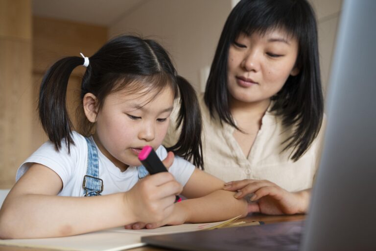 Parent helping a young child with homework at a desk