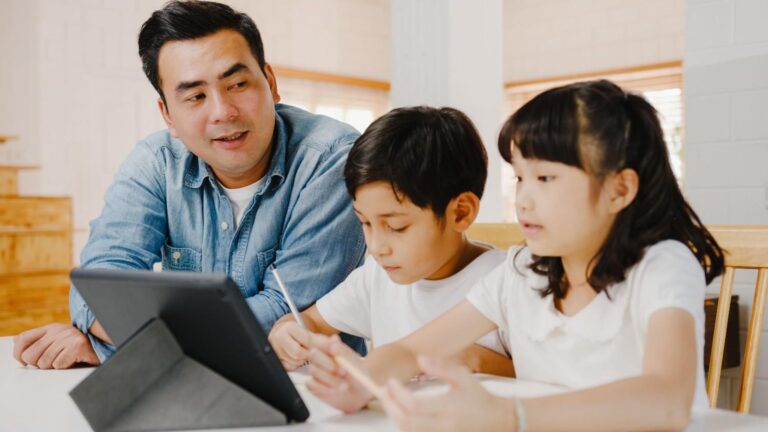 Father homeschooling children using a tablet at home