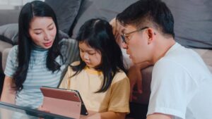 Parents and child using a tablet together at home