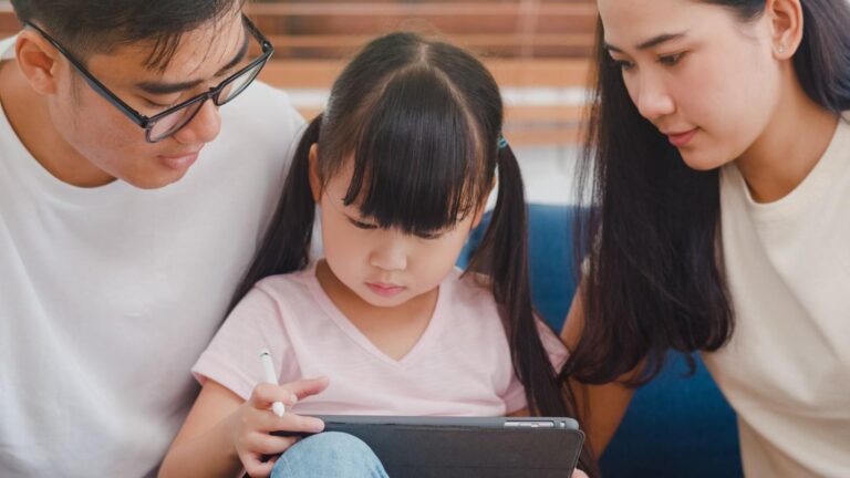 Parents helping their child learn on a tablet at home