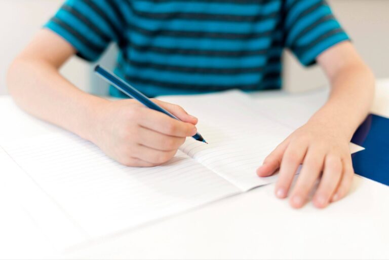 Young student practicing handwriting in a notebook during a tutoring session